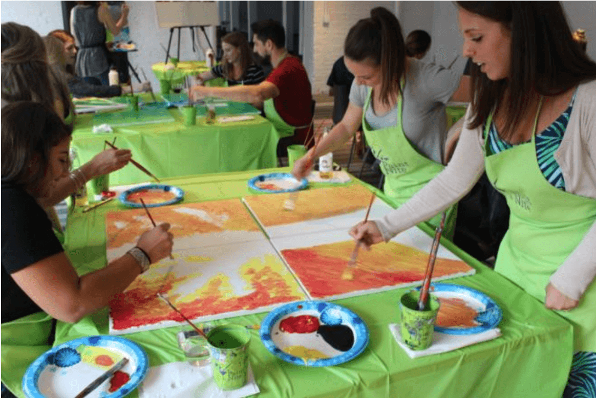 Collaborative canvas team building activity creating large group mural for corporate paint and sip events